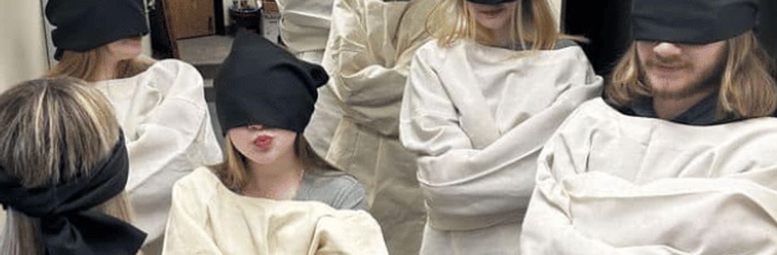 escape room players in straighjackets